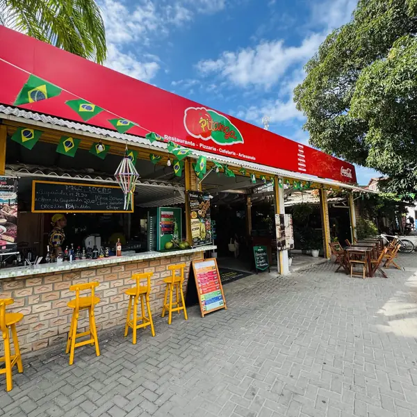 Fachada vermelha do Pitanga na Rua Esperança, com banquetas amarelas no balcão