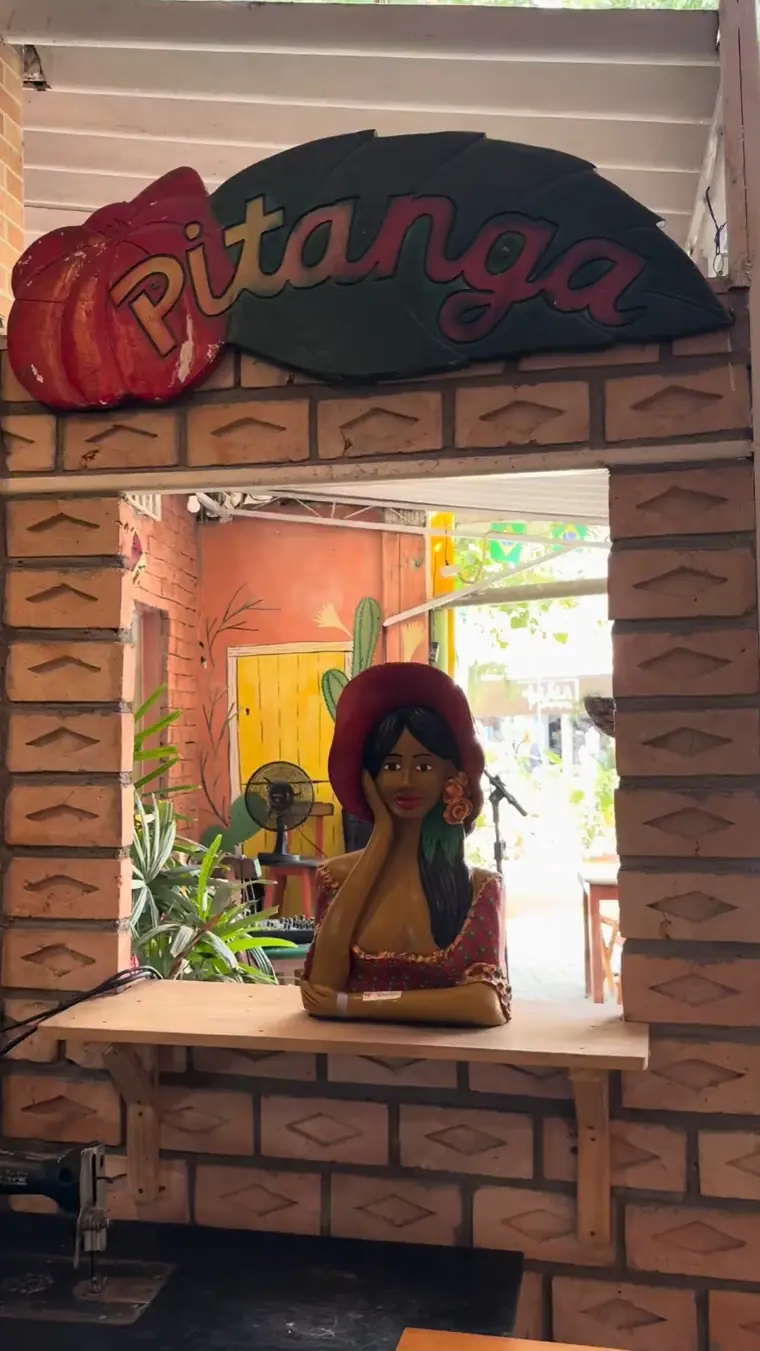 Placa de madeira do Pitanga e escultura artesanal de mulher com chapéu