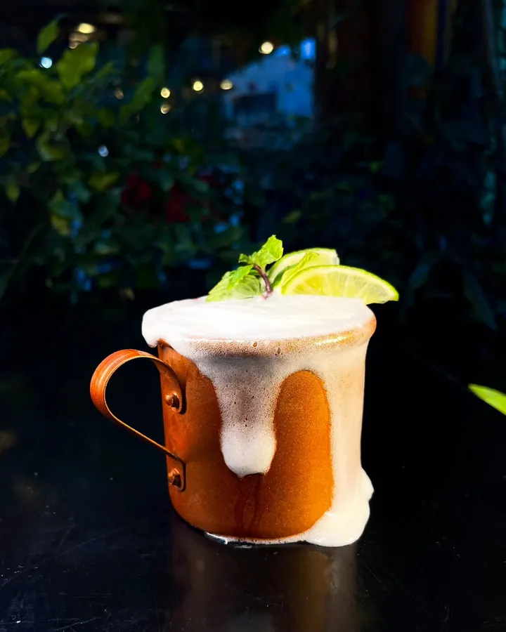 Drink gelado com espuma, limão e hortelã na caneca de cobre