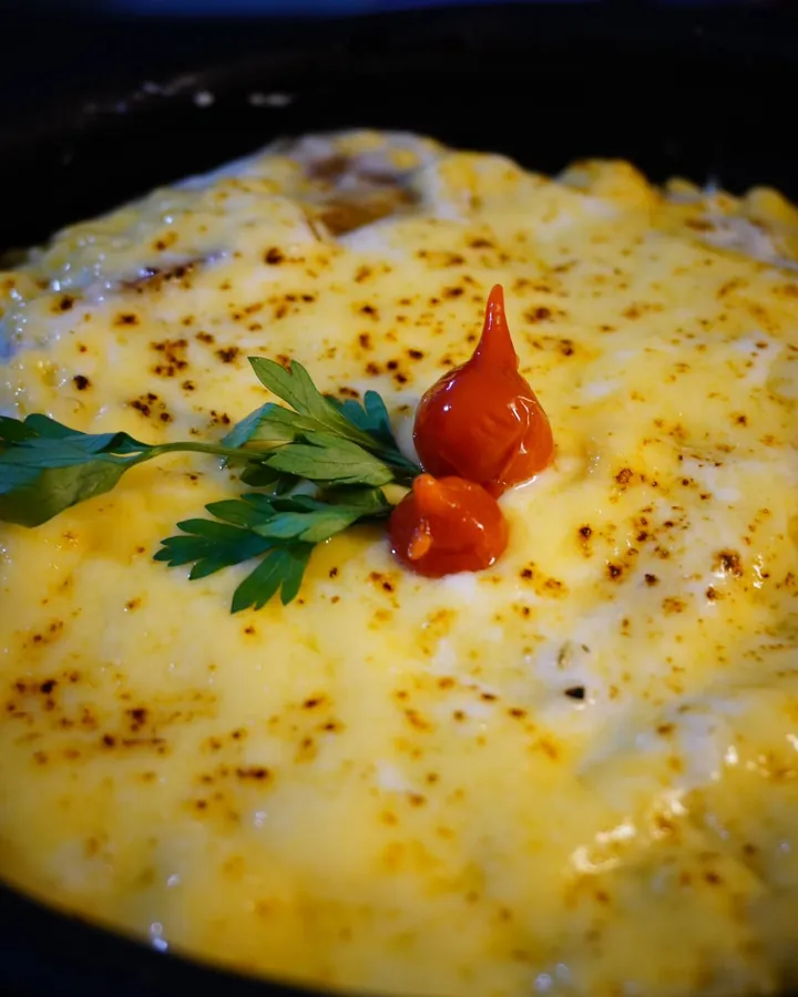 Prato gratinado com queijo dourado, salsinha e pimenta-biquinho