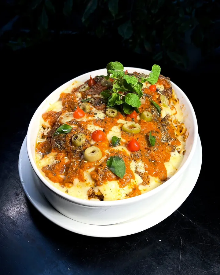 Parmegiana gratinada com molho de tomate, queijo, azeitonas e manjericão